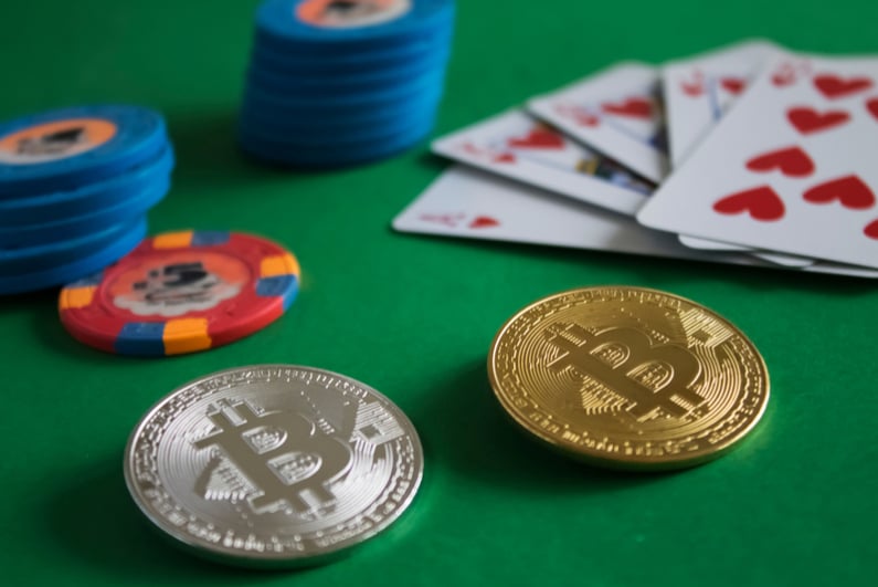 Two bitcoins on a green poker table