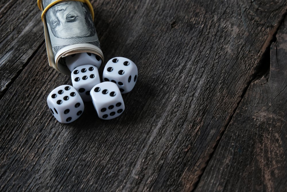 Gaming dice in a roll of US cash