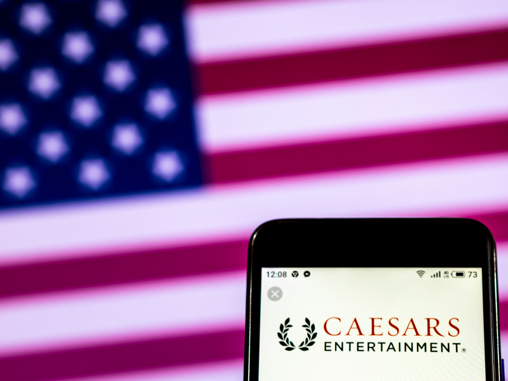 Caesars Entertainment logo on phone in front of US flag